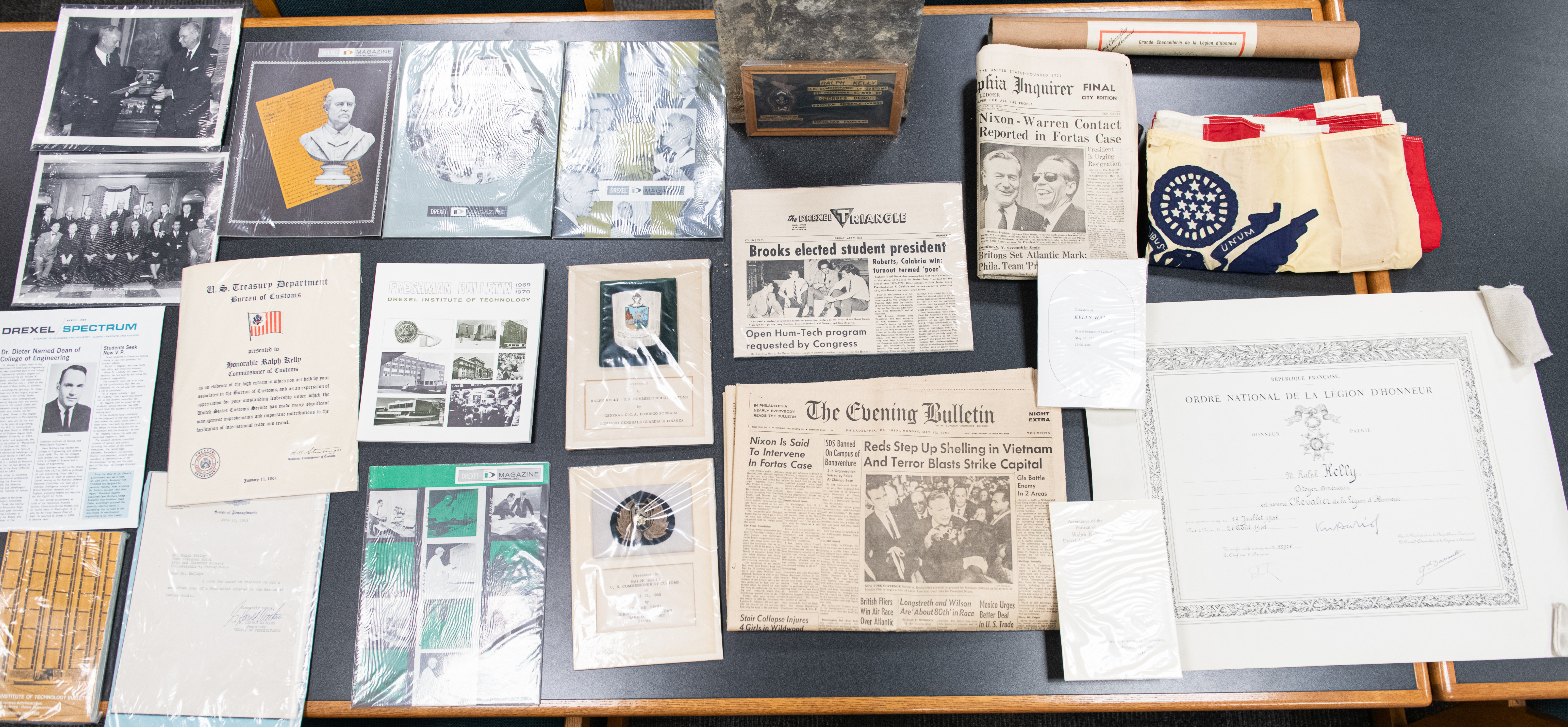 Objects from time capsule, including newspapers, Drexel publications, photographs, certificates, and a flag